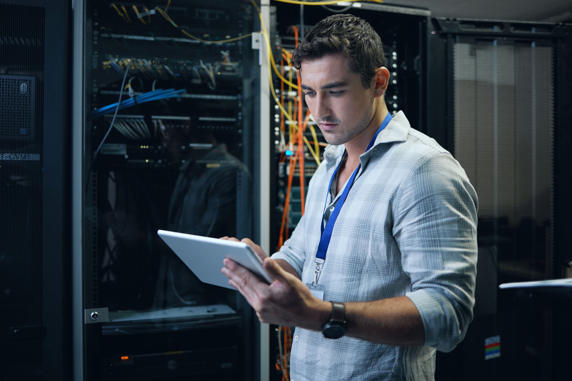 Cropped shot of a handsome young male programmer working on a tablet in a server room